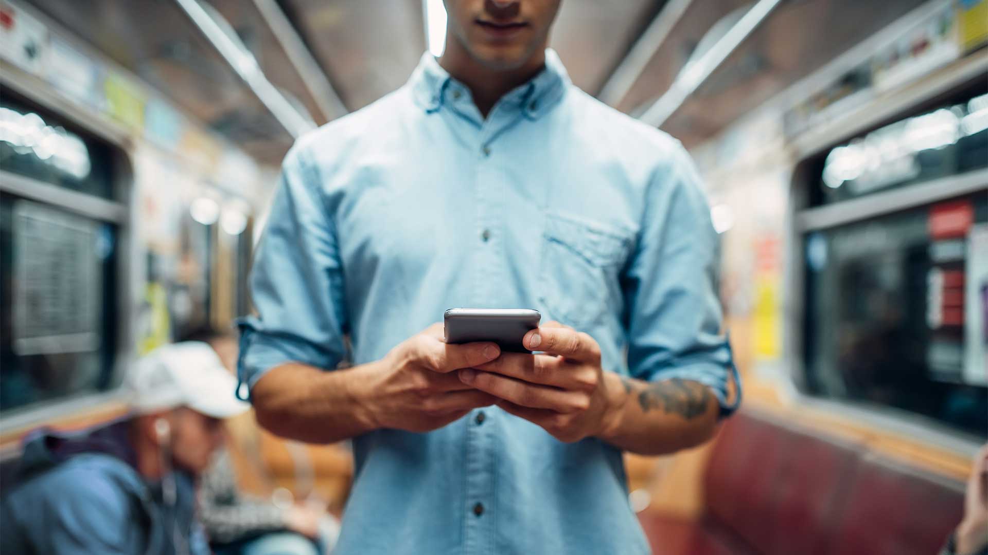 man-using-phone-in-subway-car-addicted-people-7CDXUHM